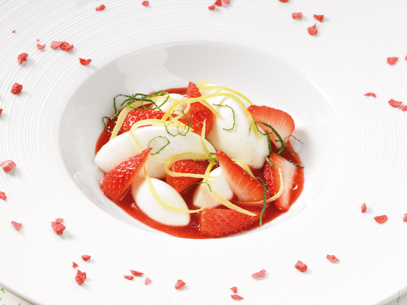 Panna cotta de yaourt Grec, sur coulis de fraises et fraises fraîches.
